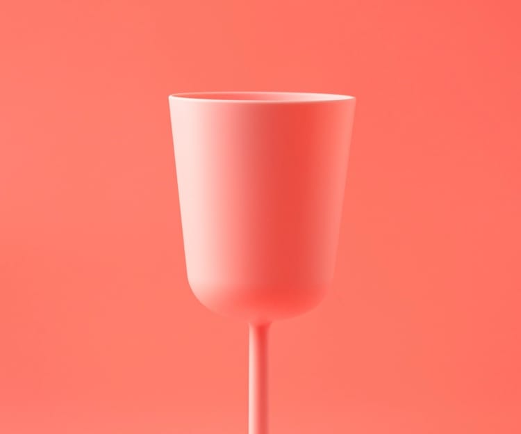 Imagem de um copo rosa à frente de um fundo rosa